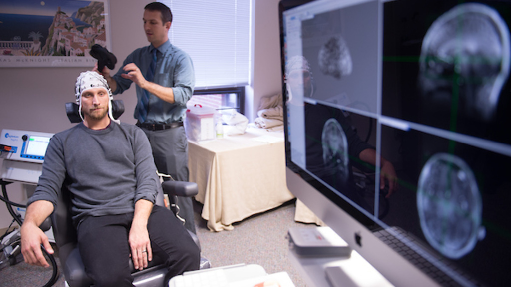 Aaron Boes, MD, PhD, demonstrates a brain stimulation technique