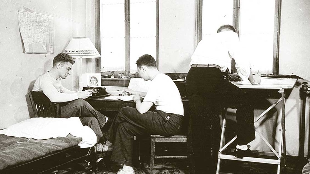 Photo from 1937 of three male students studying in a Quandrangle dorm room